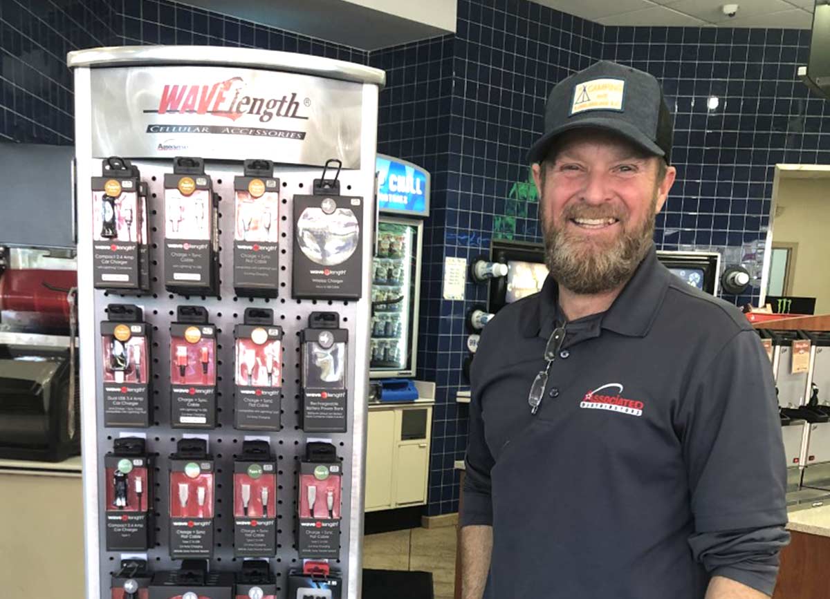 A man standing by a display of Associated Distributors products