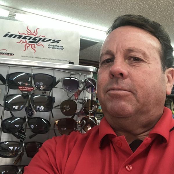 An associated distributor rep poses with a display of merchandise.
